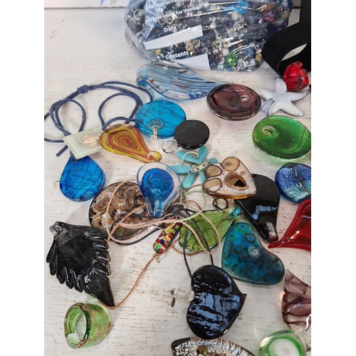 109 - A large collection of art glass necklace pendants and various beads to include Murano etc. Together ... 