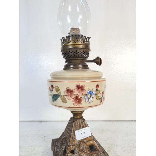 178 - A 19th century cast iron and ceramic oil lamp with hand painted floral design - approx. 54cm high