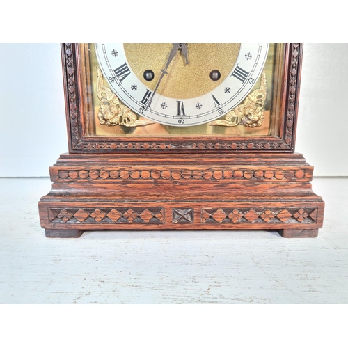 191 - A 19th century style carved oak cased chiming mantle clock with key and pendulum - approx. 32cm high... 