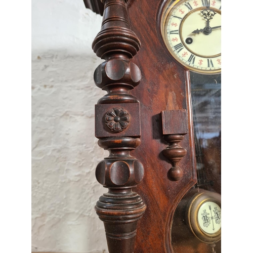 192 - A Victorian walnut cased Vienna wall clock with enamel face, key and pendulum - approx. 56.5cm high ... 