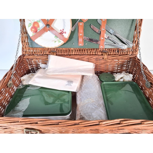 207 - A vintage Optima wicker picnic basket containing cutlery, plates etc.