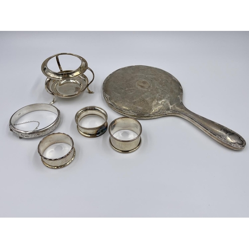 1229 - Six items of hallmarked Birmingham silver comprising hand mirror dated 1929, three napkin rings, one... 