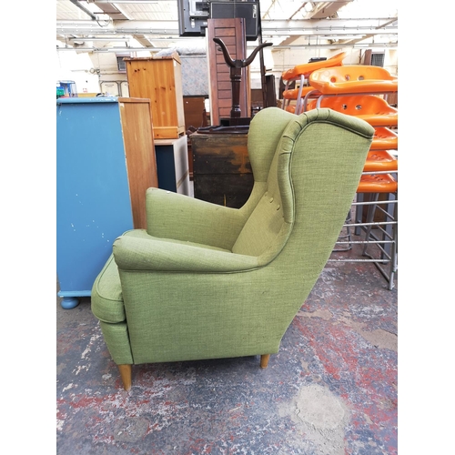 237 - A modern green upholstered wingback armchair - approx. 100cm high x 80cm wide x 76cm deep