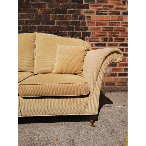 266A - A Regency style beige upholstered two seater sofa with mahogany supports and brass casters - approx.... 