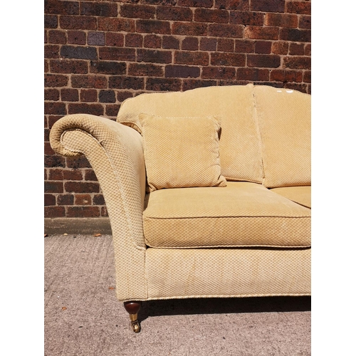 266A - A Regency style beige upholstered two seater sofa with mahogany supports and brass casters - approx.... 