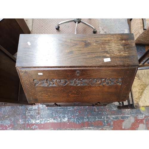 268 - A mid/late 20th century oak bureau with carved floral design, three drawers and fall front - approx.... 