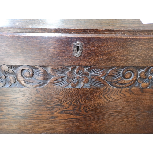 268 - A mid/late 20th century oak bureau with carved floral design, three drawers and fall front - approx.... 