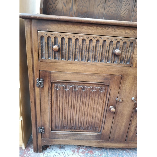 269 - A late 20th century oak linenfold Welsh dresser with upper two tier plate rack, two drawers and two ... 