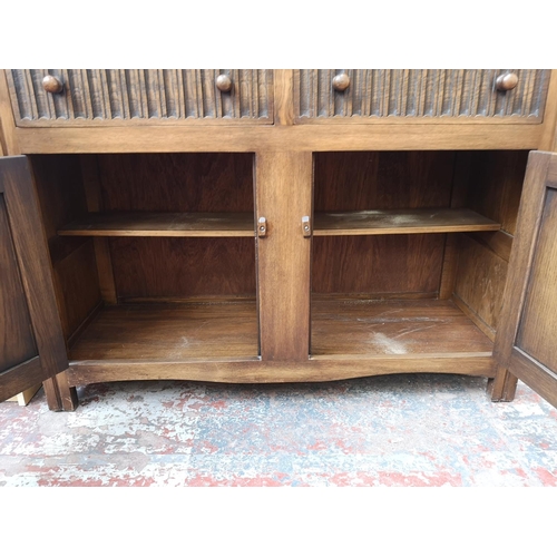 269 - A late 20th century oak linenfold Welsh dresser with upper two tier plate rack, two drawers and two ... 