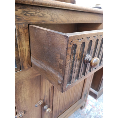 269 - A late 20th century oak linenfold Welsh dresser with upper two tier plate rack, two drawers and two ... 