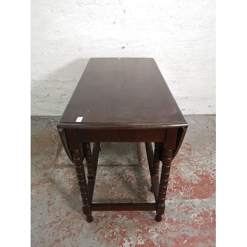 275 - An oak drop leaf gate leg oval dining table with bobbin turned supports - approx. 78.5cm high x 106c... 