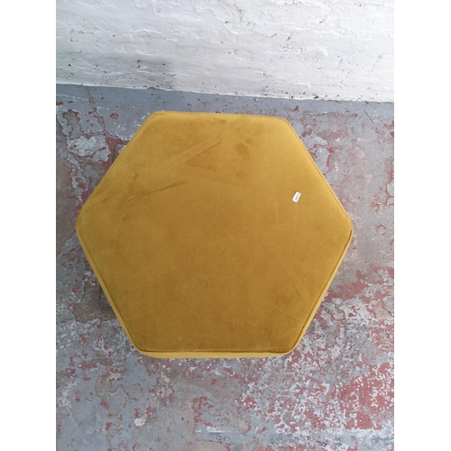 314 - A DFS yellow upholstered hexagonal footstool with copper effect supports - approx. 38cm high x 69cm ... 