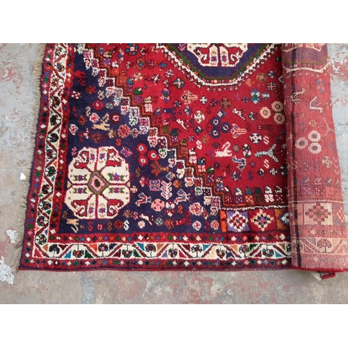 317 - A Persian style red rug - approx. 298cm x 210cm