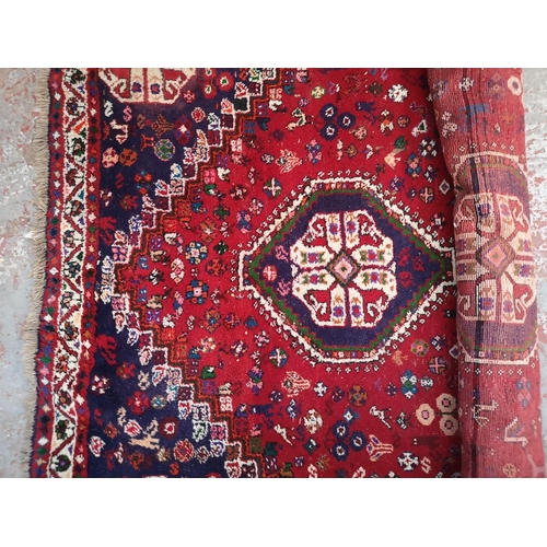 317 - A Persian style red rug - approx. 298cm x 210cm