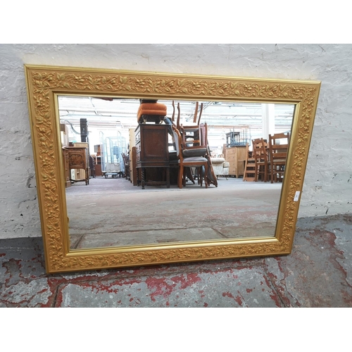 354 - A 19th century style gilt framed wall mirror with foliage design - approx. 90cm wide x 65cm high