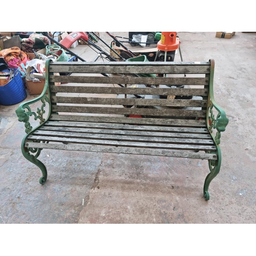 597 - A Victorian style cast iron and wooden slatted two seater garden bench with lions head design - appr... 