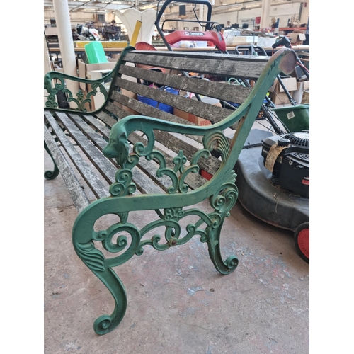 597 - A Victorian style cast iron and wooden slatted two seater garden bench with lions head design - appr... 