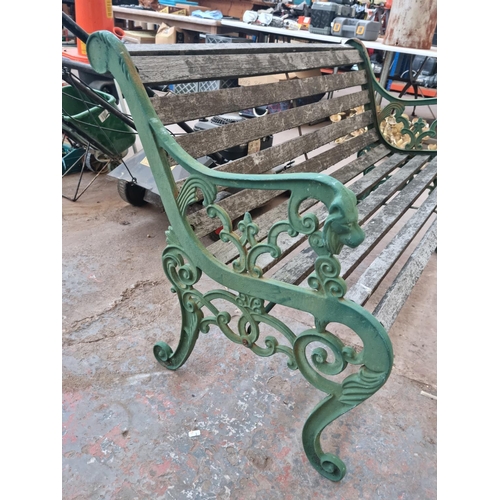 597 - A Victorian style cast iron and wooden slatted two seater garden bench with lions head design - appr... 