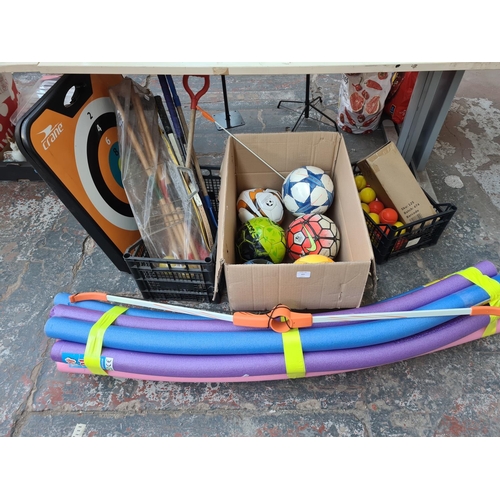 655 - Three boxes containing various sports equipment to include footballs, croquet set, foam noodle float... 