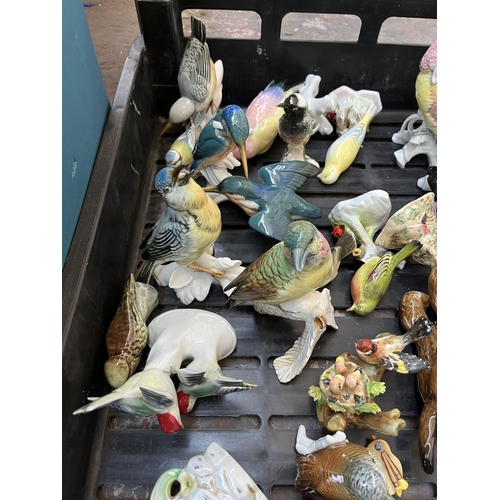 628 - Four boxes containing assorted ceramics to include Wade Whimsies, bird figurines, collectors plates ... 