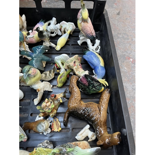 628 - Four boxes containing assorted ceramics to include Wade Whimsies, bird figurines, collectors plates ... 