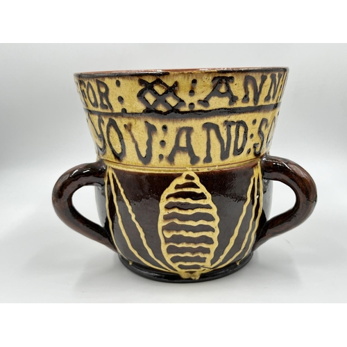19 - A Wrotham style slipware loving cup - approx. 17.5cm high