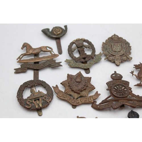 1083 - Twelve assorted vintage military cap badges to include Middlesex, North Staffs etc.