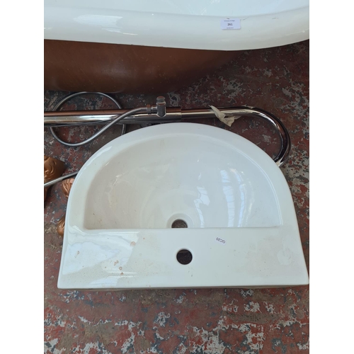 261 - An enamelled steel bath tub with four cast metal supports, white porcelain sink and chrome floor sta... 