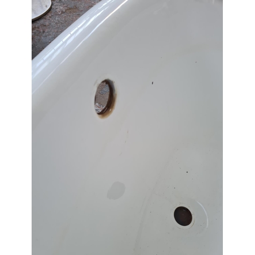 261 - An enamelled steel bath tub with four cast metal supports, white porcelain sink and chrome floor sta... 