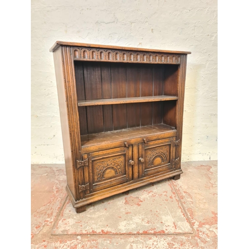 275 - A mid/late 20th century carved oak bookcase with two doors and two upper shelves - approx. 92cm high... 