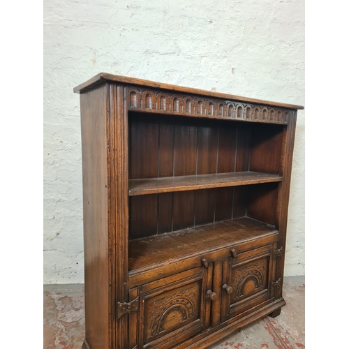 275 - A mid/late 20th century carved oak bookcase with two doors and two upper shelves - approx. 92cm high... 