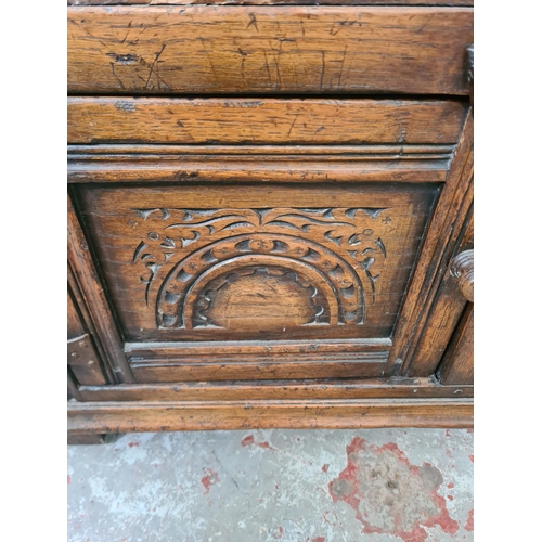 275 - A mid/late 20th century carved oak bookcase with two doors and two upper shelves - approx. 92cm high... 