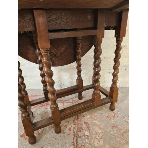 286 - An oak drop leaf gate leg oval occasional table with barley twist supports - approx. 71cm high x 83c... 