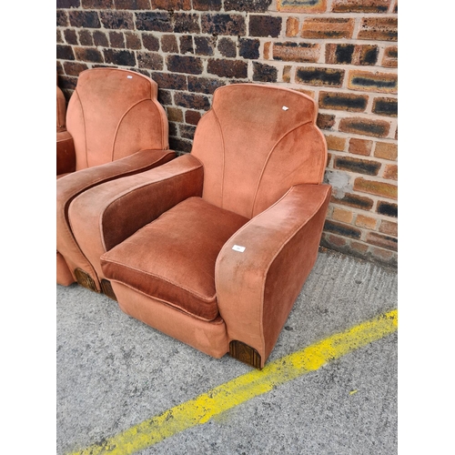 299 - An Art Deco salmon pink upholstered and carved oak three piece lounge suite comprising two armchairs... 