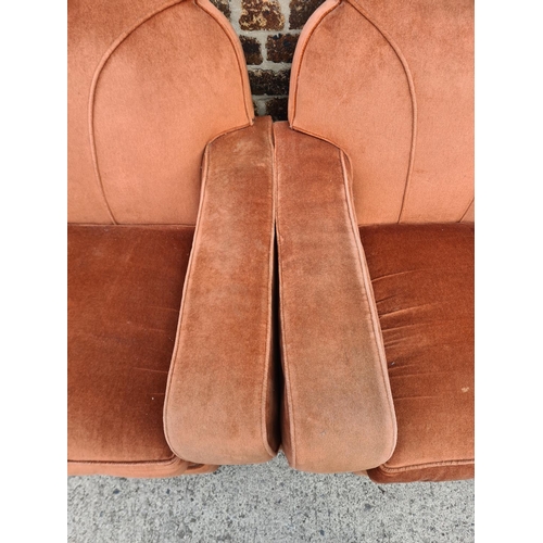 299 - An Art Deco salmon pink upholstered and carved oak three piece lounge suite comprising two armchairs... 