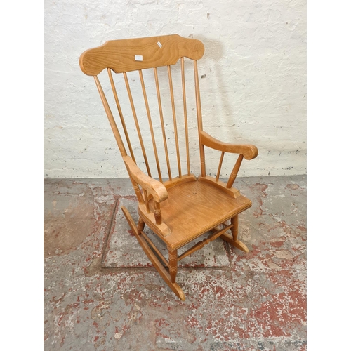 317 - A modern beech spindle back farmhouse rocking chair - approx. 96cm high x 55cm wide x 43cm deep