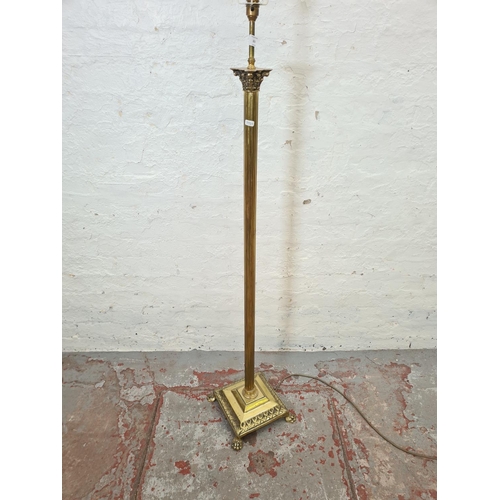 321 - A brass Corinthian column standard lamp with lion paw supports - approx. 156cm high