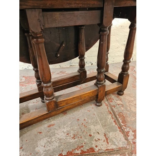 327 - A mid 20th century oak drop leaf gate leg circular occasional table - approx. 53cm high x 83cm in di... 