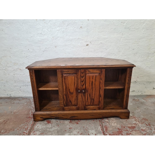 330 - An oak TV stand - approx. 63cm high x 105cm wide x 48cm deep