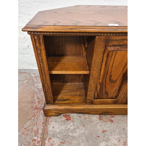 330 - An oak TV stand - approx. 63cm high x 105cm wide x 48cm deep