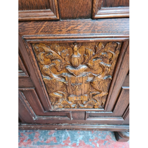 331 - A carved oak dresser with upper two tier plate rack, three drawers, two cupboard doors and baluster ... 