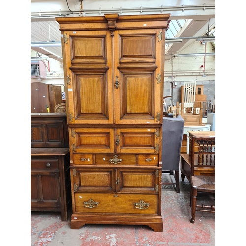 334 - An early 20th century Maple & Co. of London oak linen press with two upper cupboard doors, three int... 