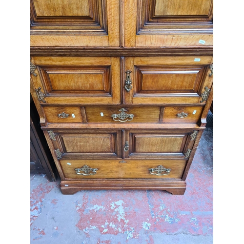 334 - An early 20th century Maple & Co. of London oak linen press with two upper cupboard doors, three int... 