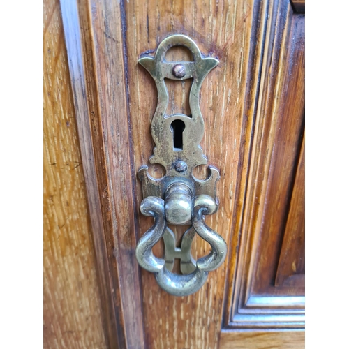 334 - An early 20th century Maple & Co. of London oak linen press with two upper cupboard doors, three int... 