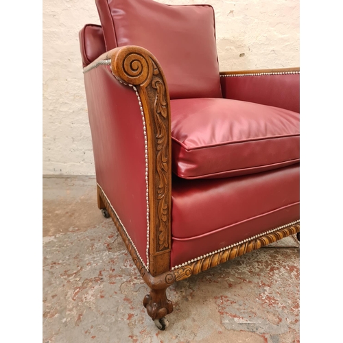 340 - A 1930s carved oak and red vinyl armchair with ball and claw supports and casters - approx. 96cm hig... 