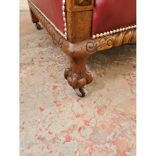 340 - A 1930s carved oak and red vinyl armchair with ball and claw supports and casters - approx. 96cm hig... 