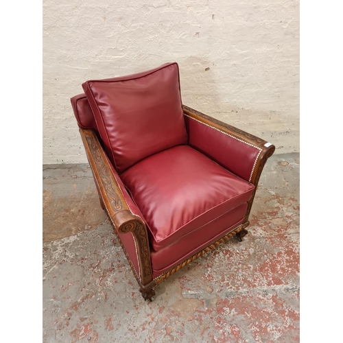 340 - A 1930s carved oak and red vinyl armchair with ball and claw supports and casters - approx. 96cm hig... 