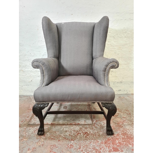 347 - An early 20th century grey upholstered wing back armchair with carved mahogany supports and lower st... 