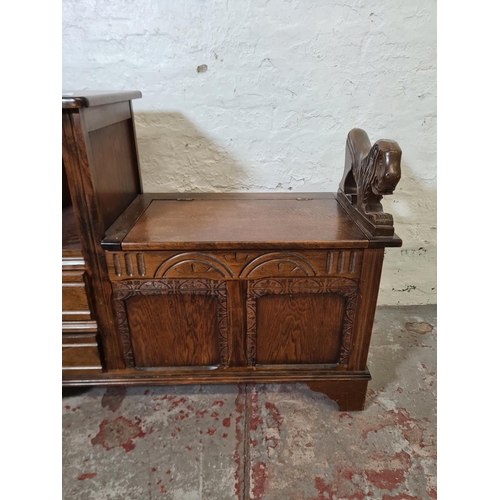 354 - An oak telephone seat with two drawers, hinged lid and lion design armrest - approx. 73cm high x 92c... 