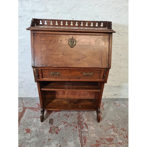 365 - An early 20th century oak bureau with fretwork galleried top, fall front, single drawer and two lowe... 